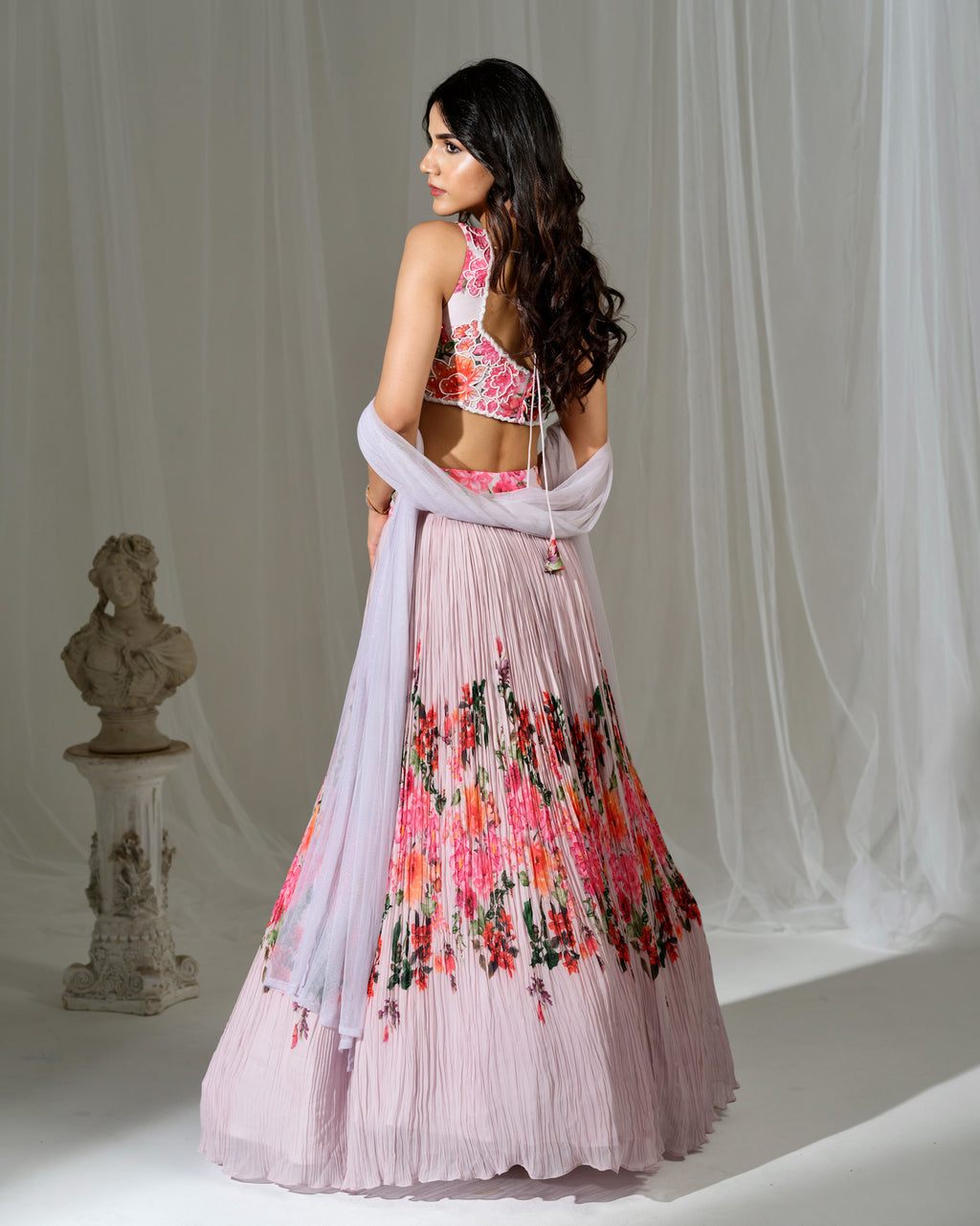 Woman wearing a floral dress with a white shawl in a studio setting