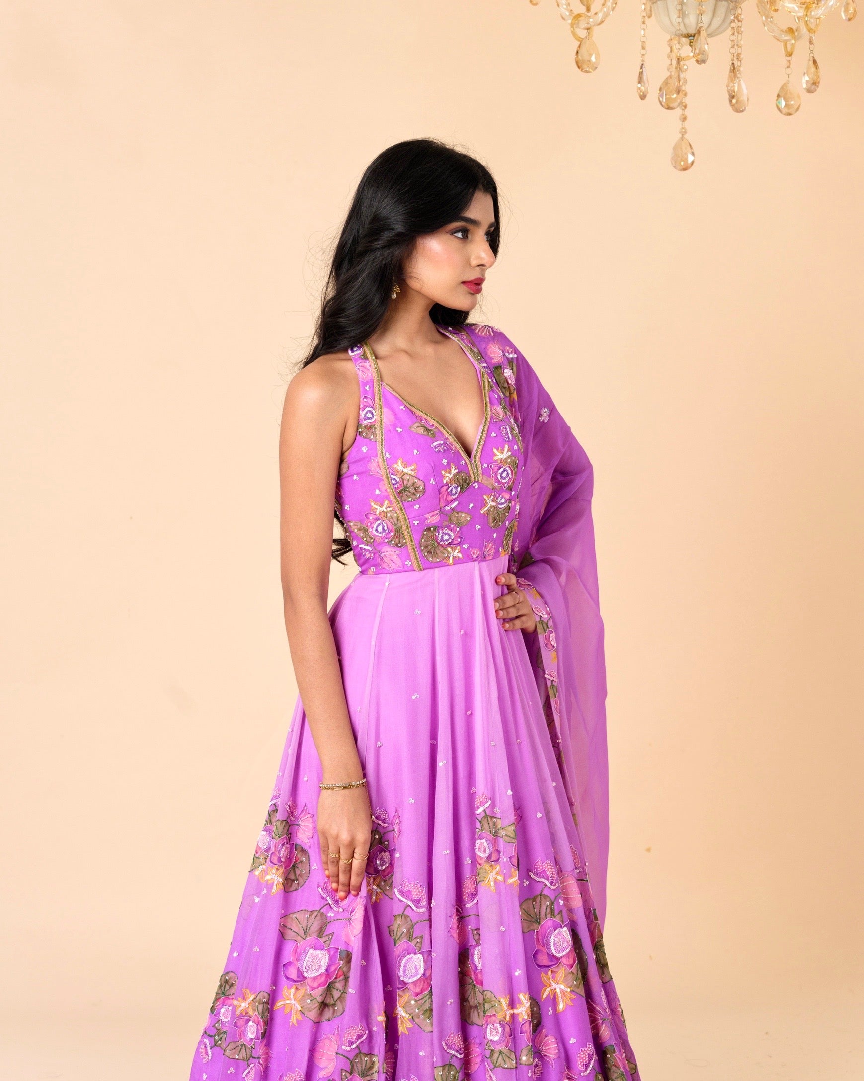 Woman wearing a purple embroidered dress on a beige background