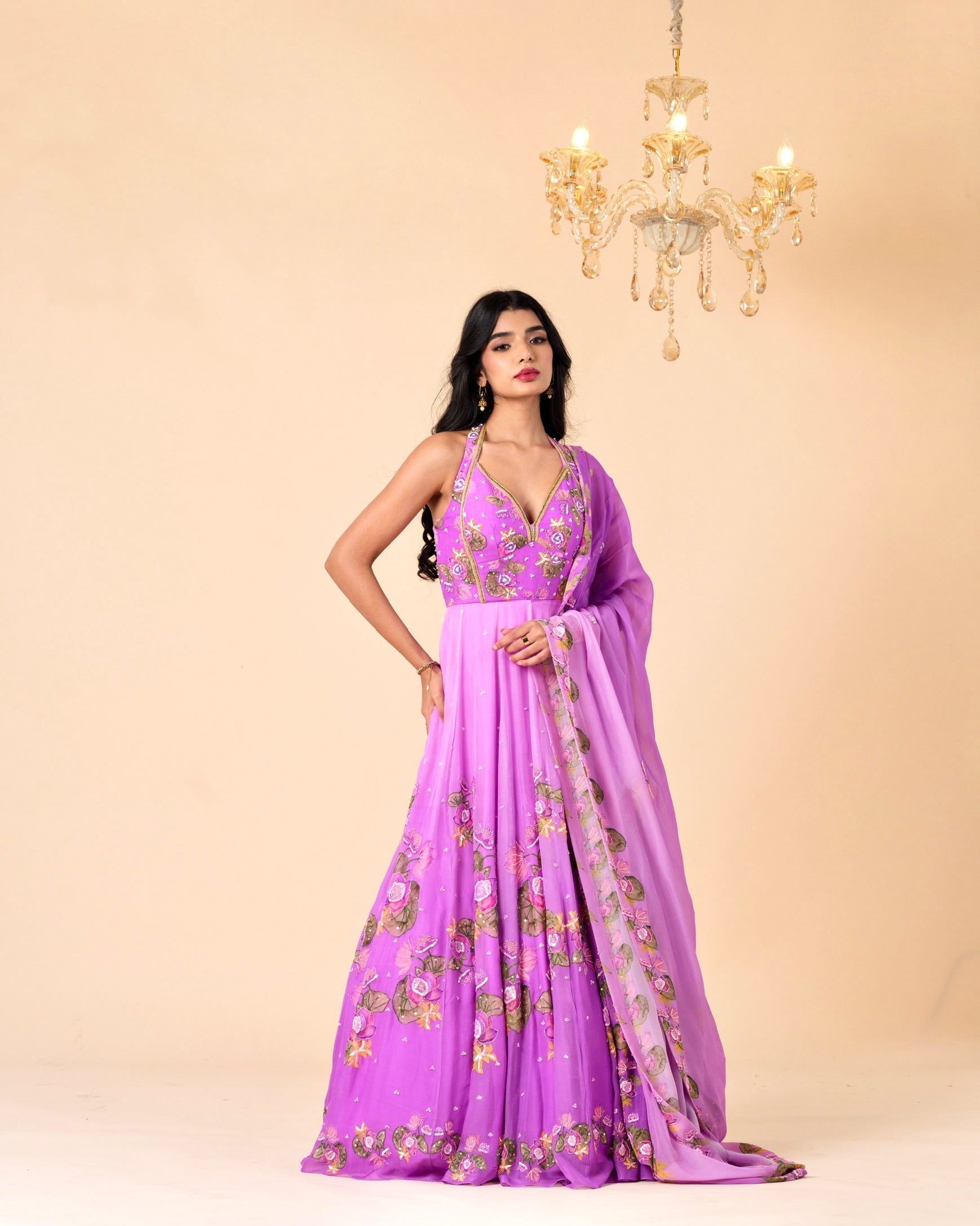 Woman wearing a purple embroidered gown with a beige background