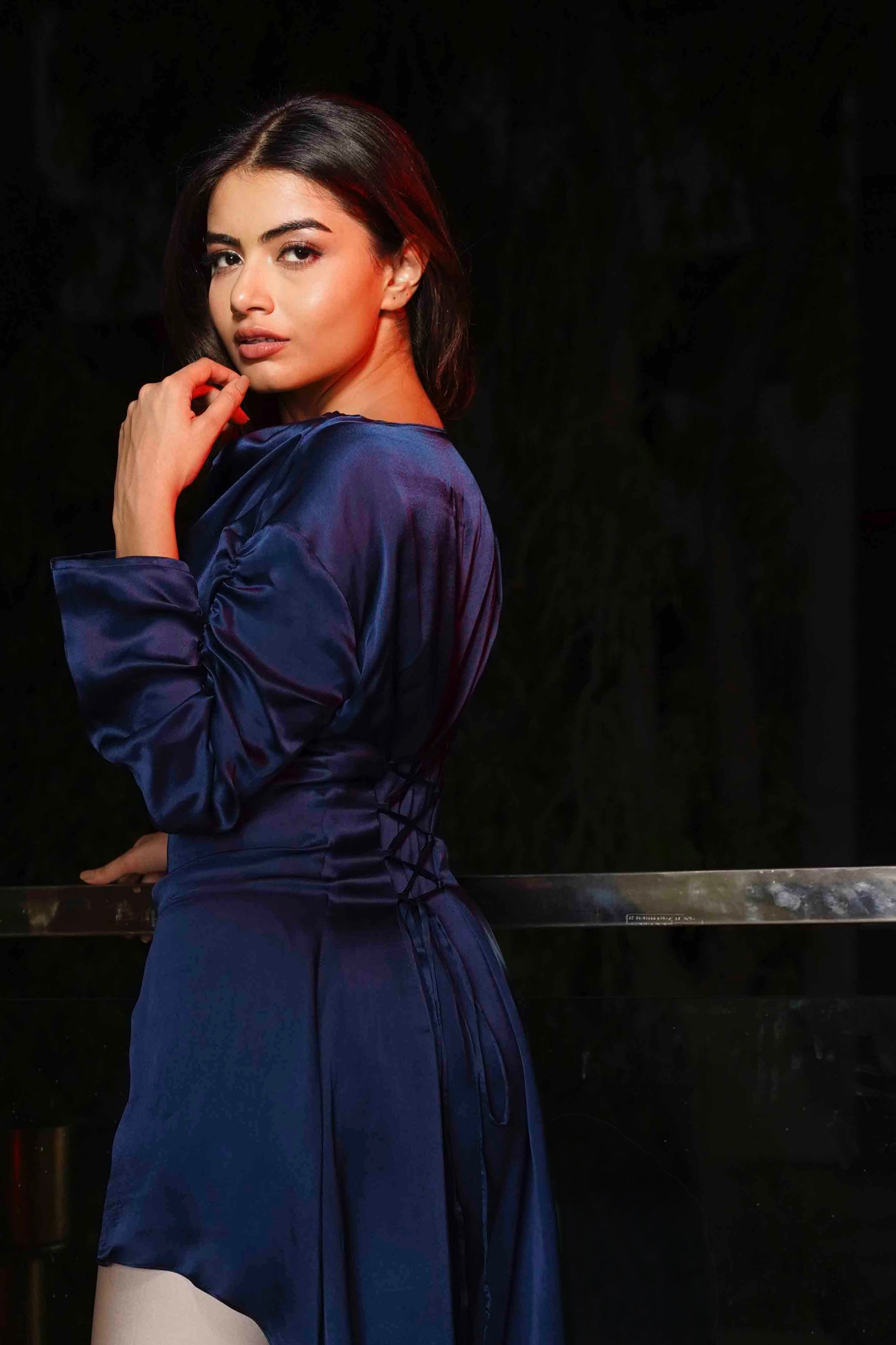 Woman wearing a blue dress against a dark background