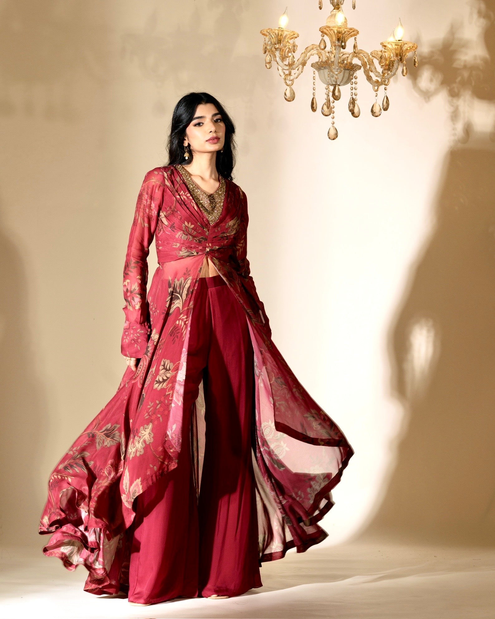 Woman in a red traditional outfit with floral patterns against a beige background