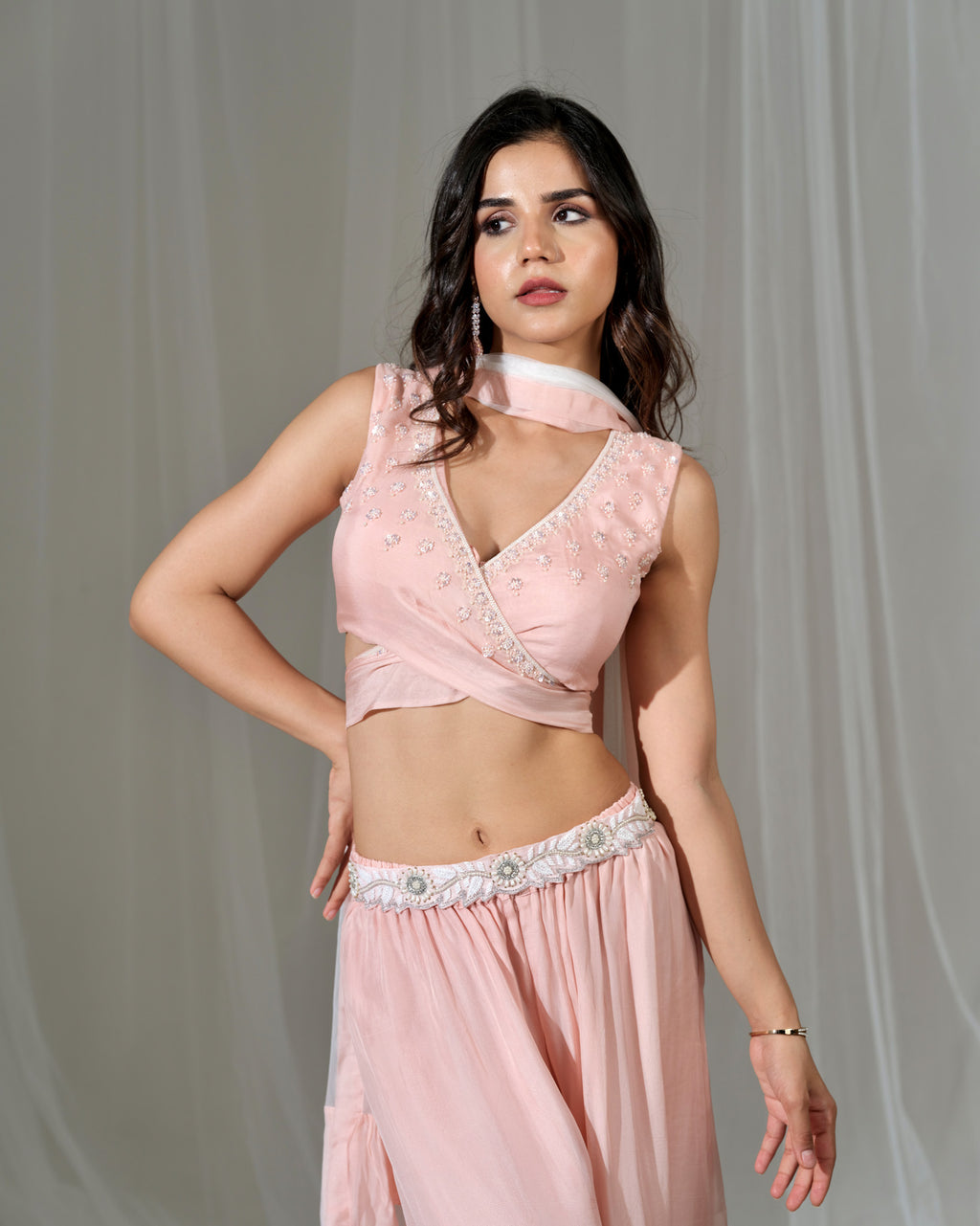 Woman wearing a pink traditional outfit with a plain background