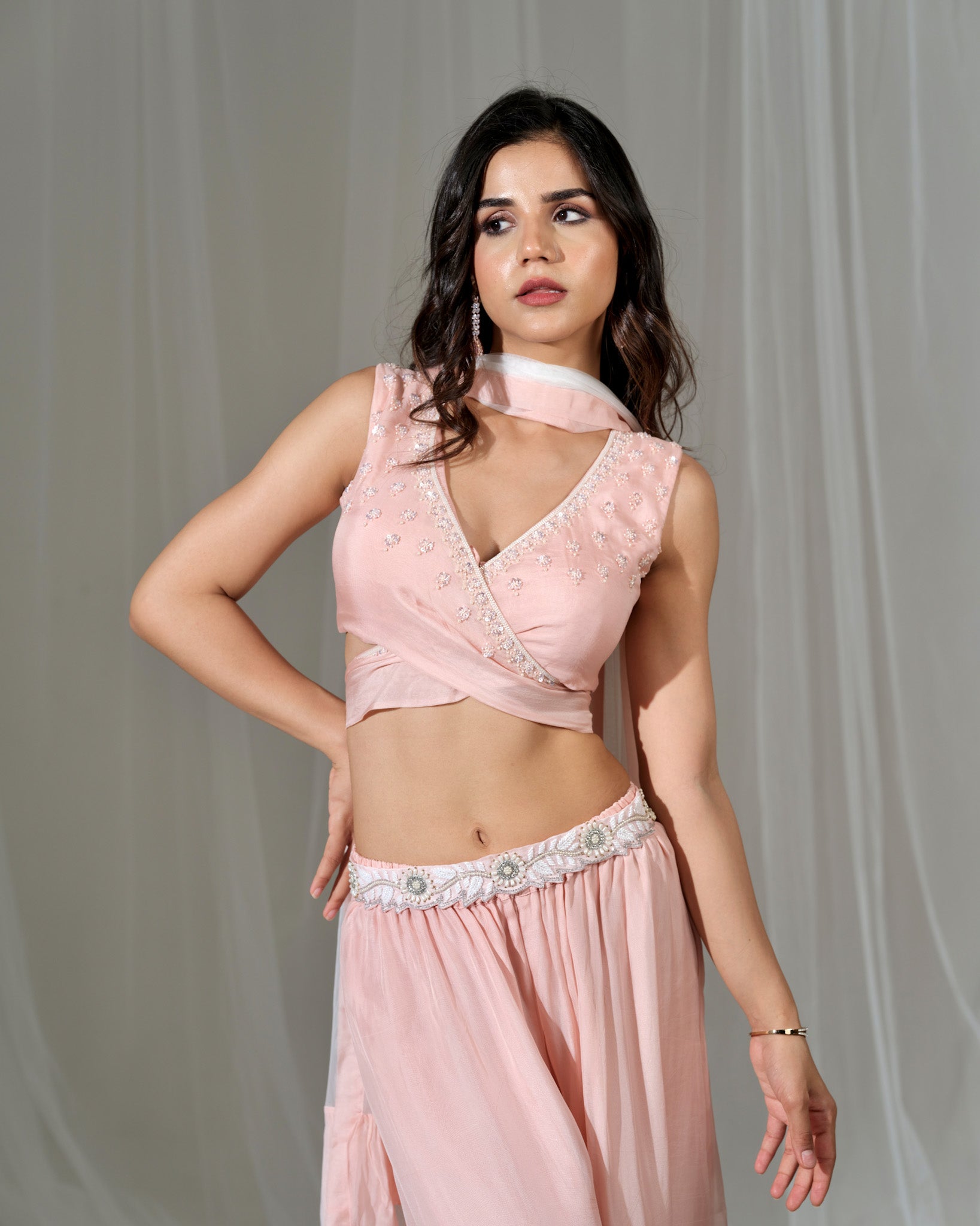 Woman wearing a pink traditional outfit with a plain background