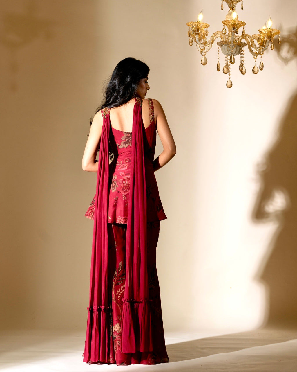 Woman in a red evening gown with a chandelier in the background