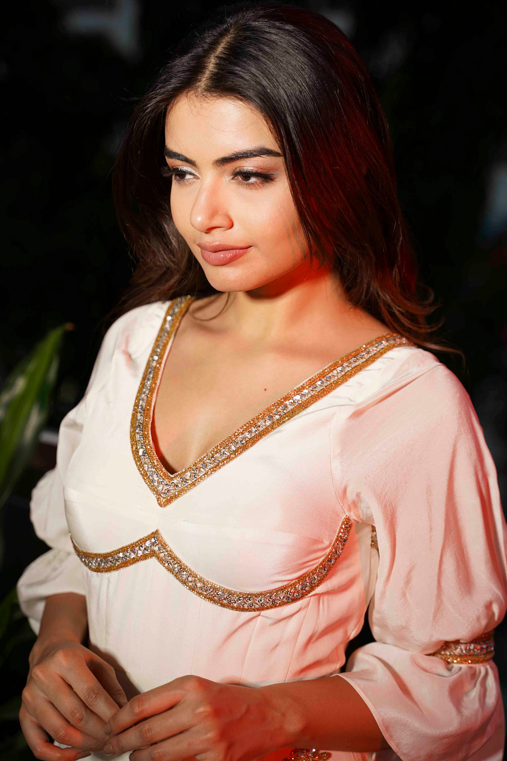 Woman wearing a light pink traditional outfit with intricate detailing