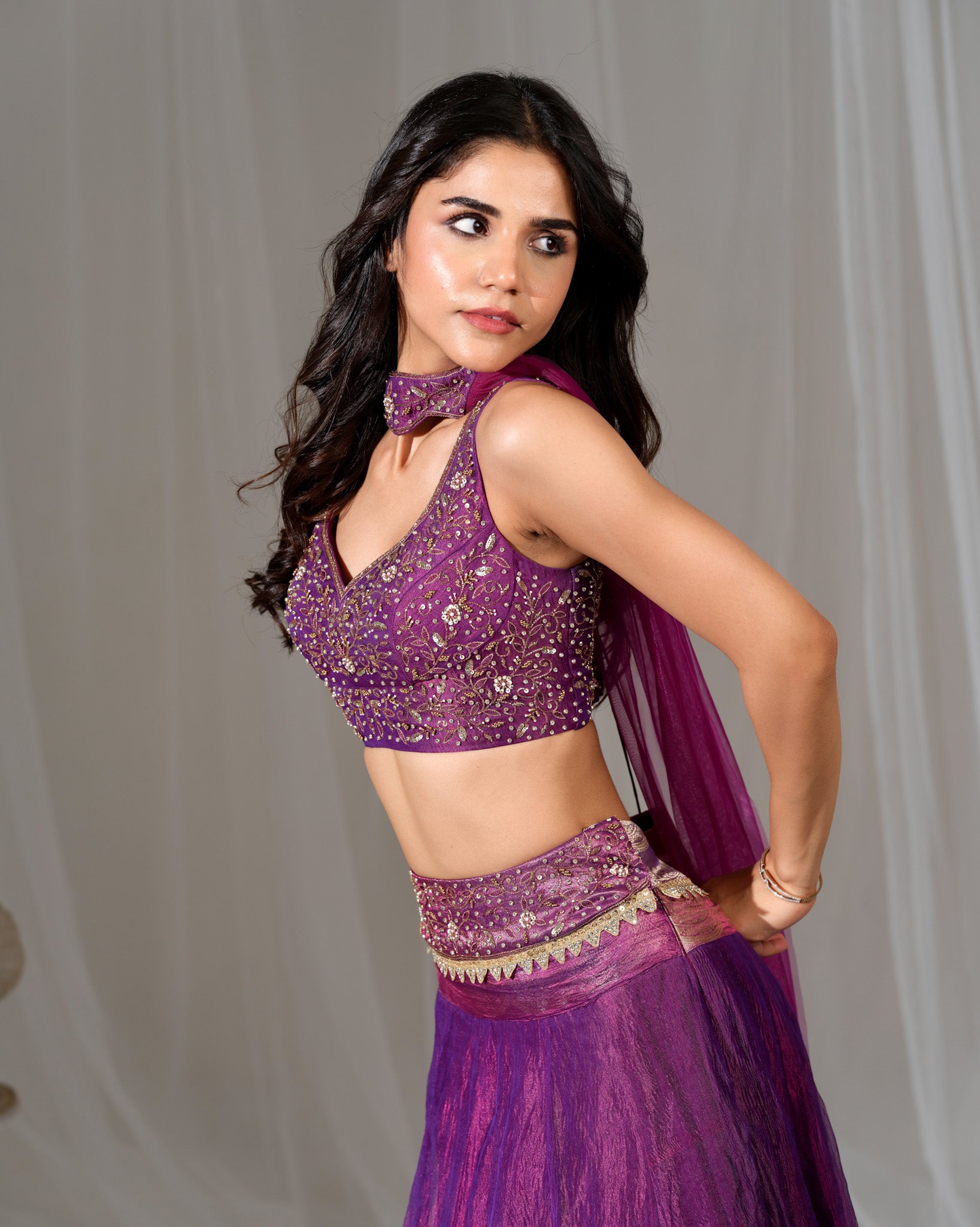 Woman wearing a purple traditional outfit with a plain background