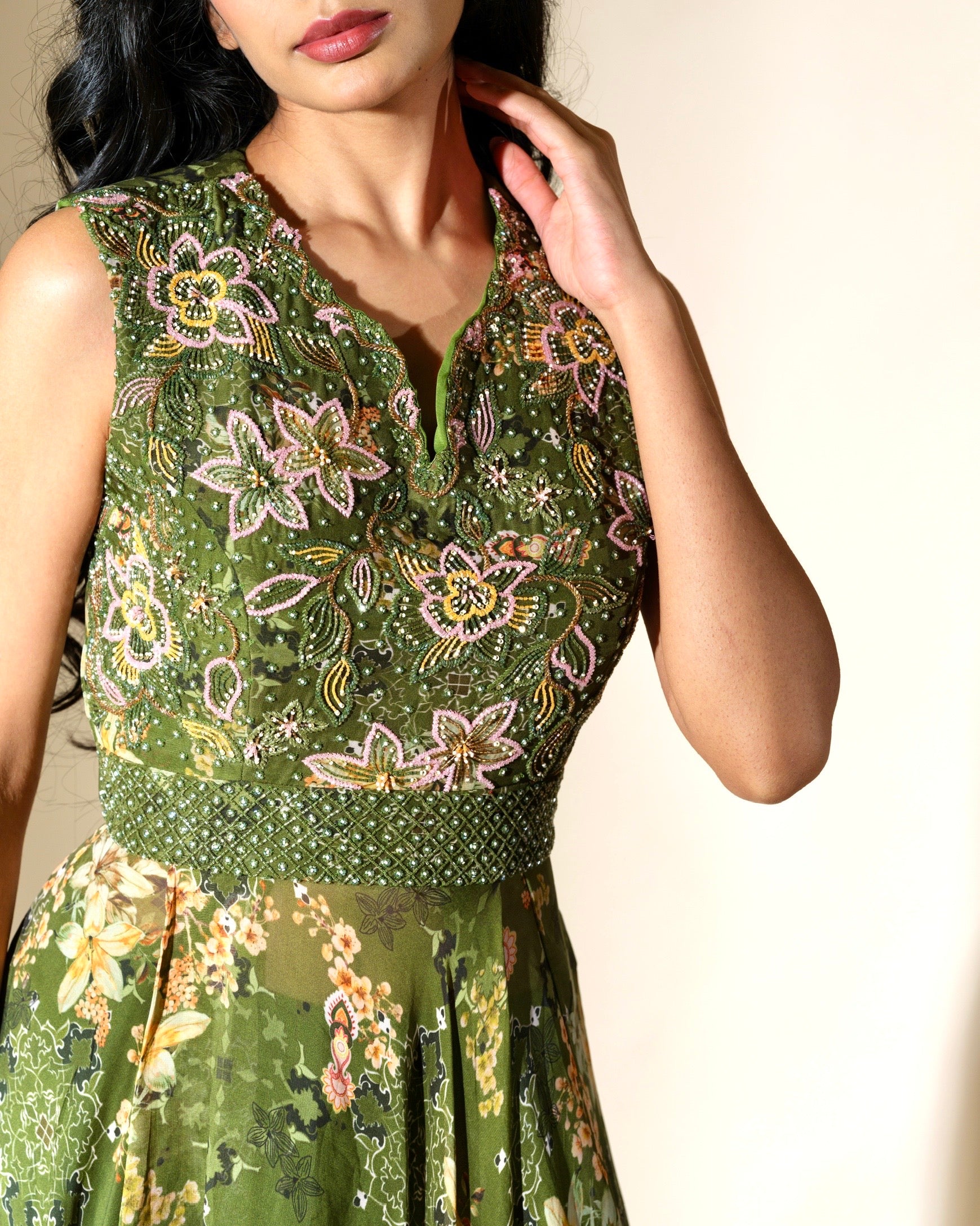 Woman wearing a green floral dress against a neutral background