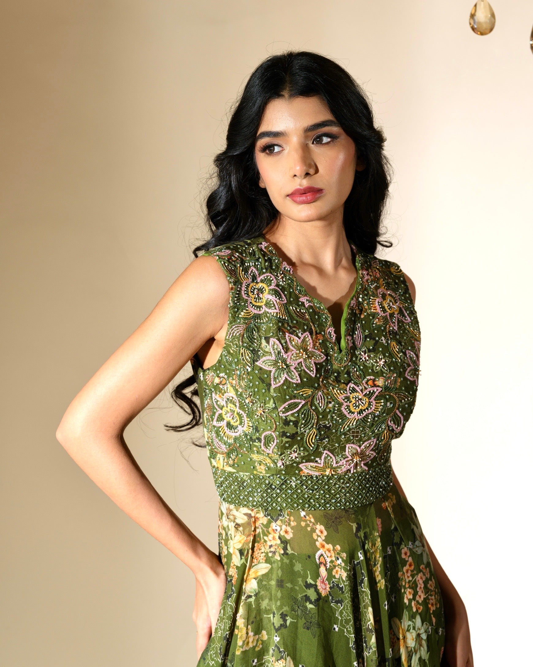 Woman wearing a green floral dress against a beige background