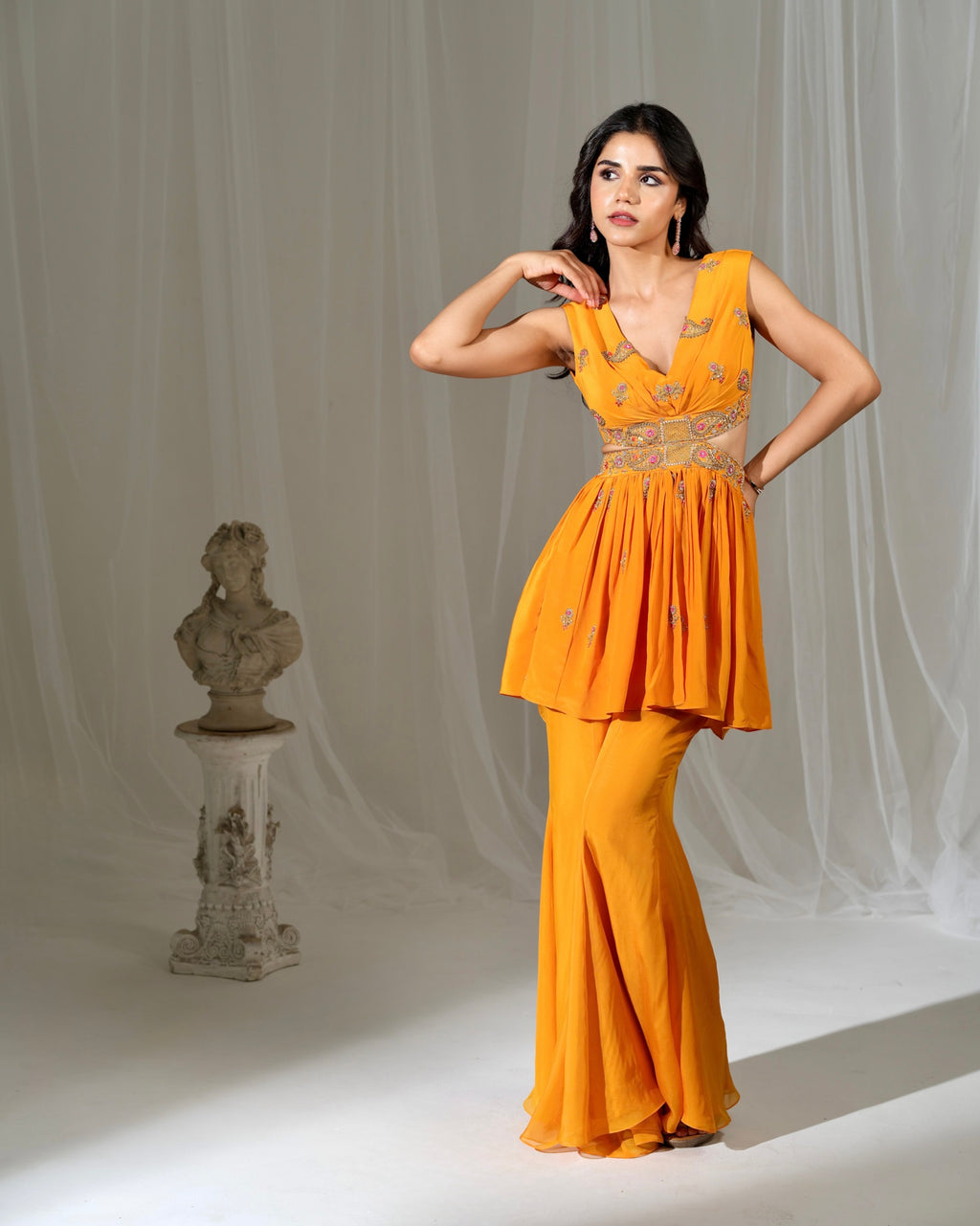 Woman in a yellow outfit posing against a neutral background