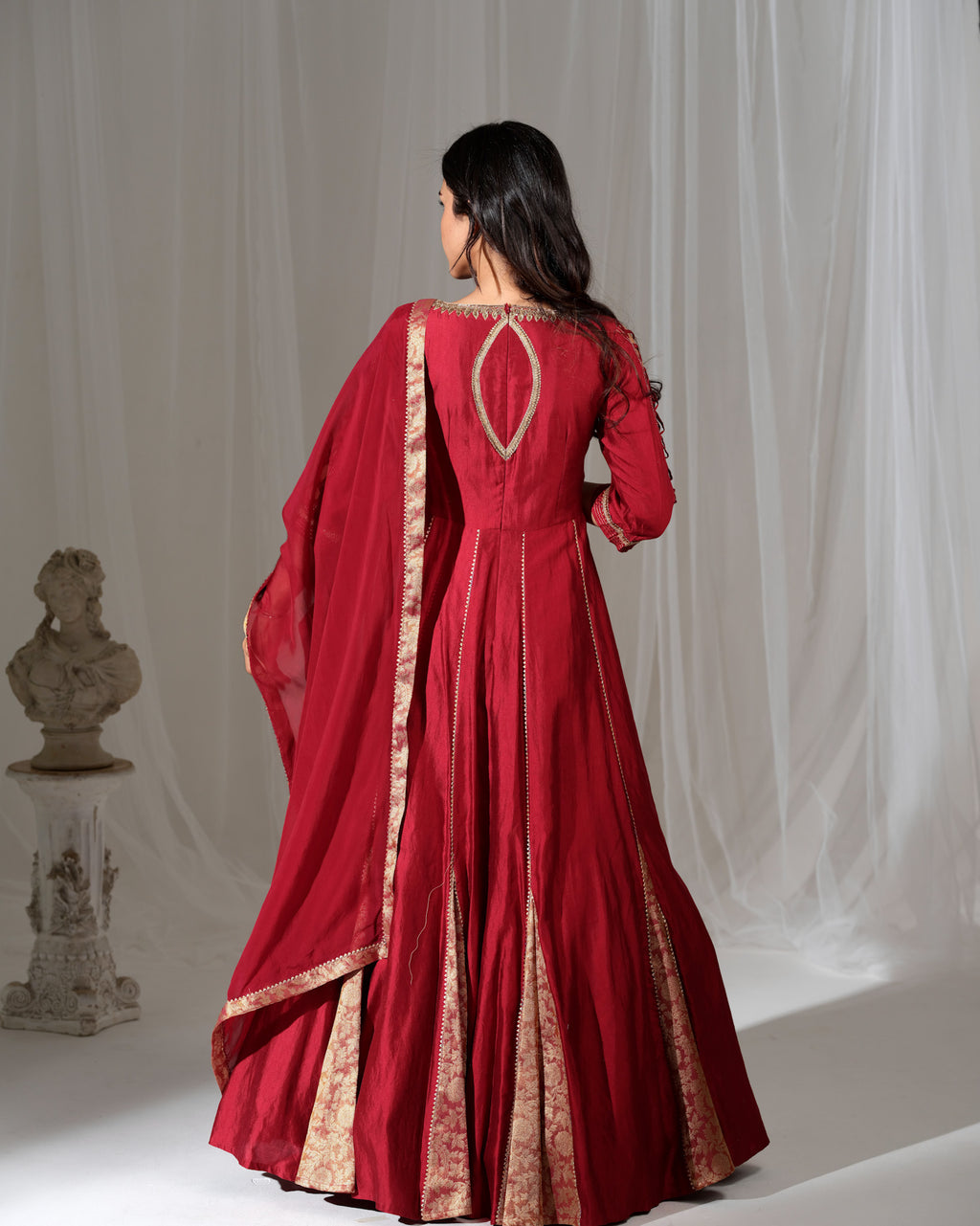 Red traditional outfit with gold embroidery on a white background