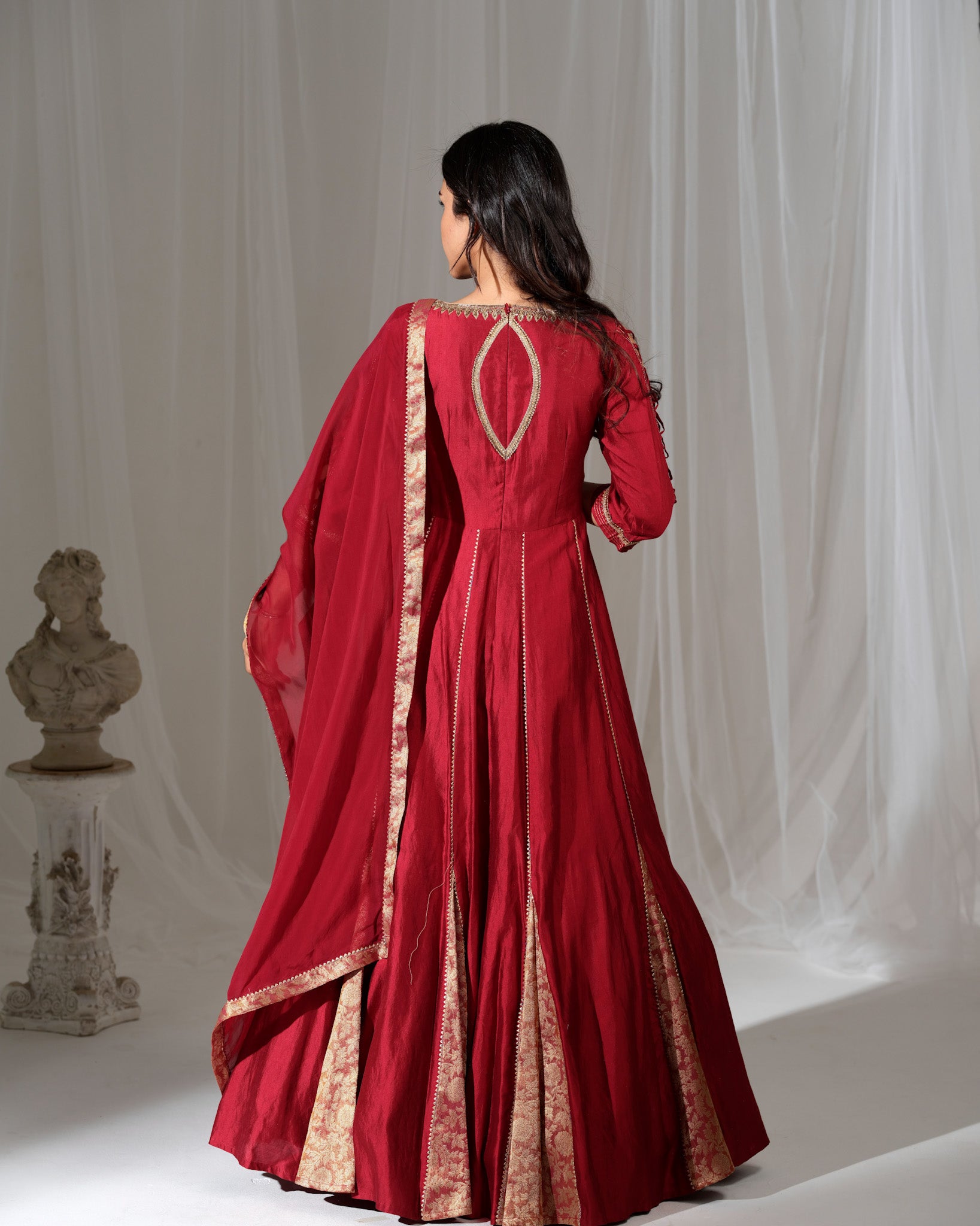 Red traditional outfit with gold embroidery on a white background