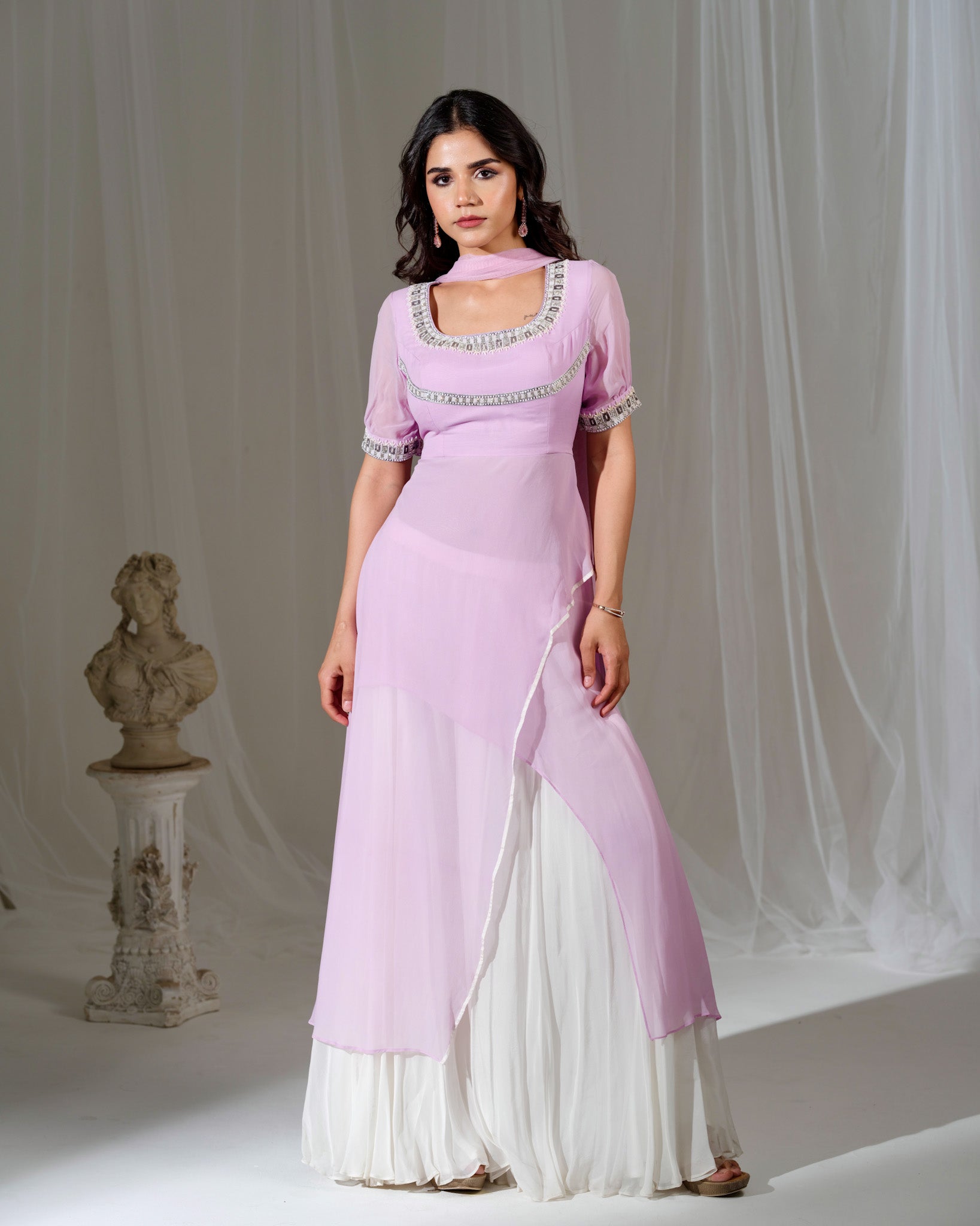 Woman wearing a pink and white traditional outfit with a gray background