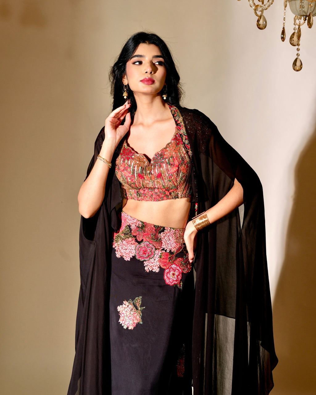 Woman wearing a floral top and black outfit with a beige background