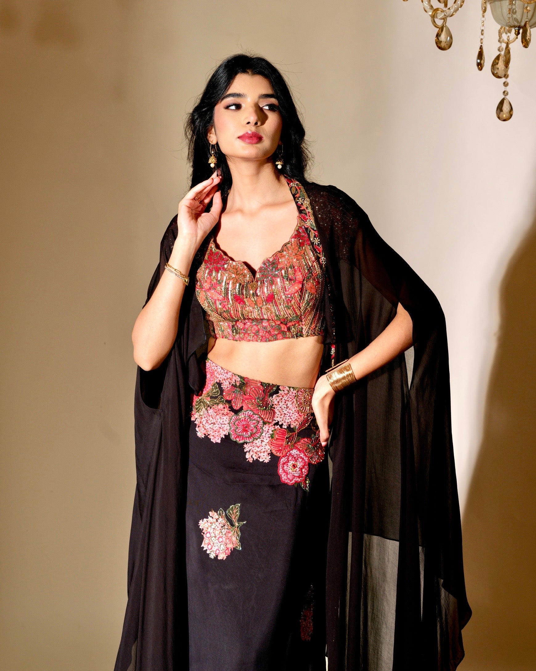 Woman wearing a floral top and black outfit with a beige background