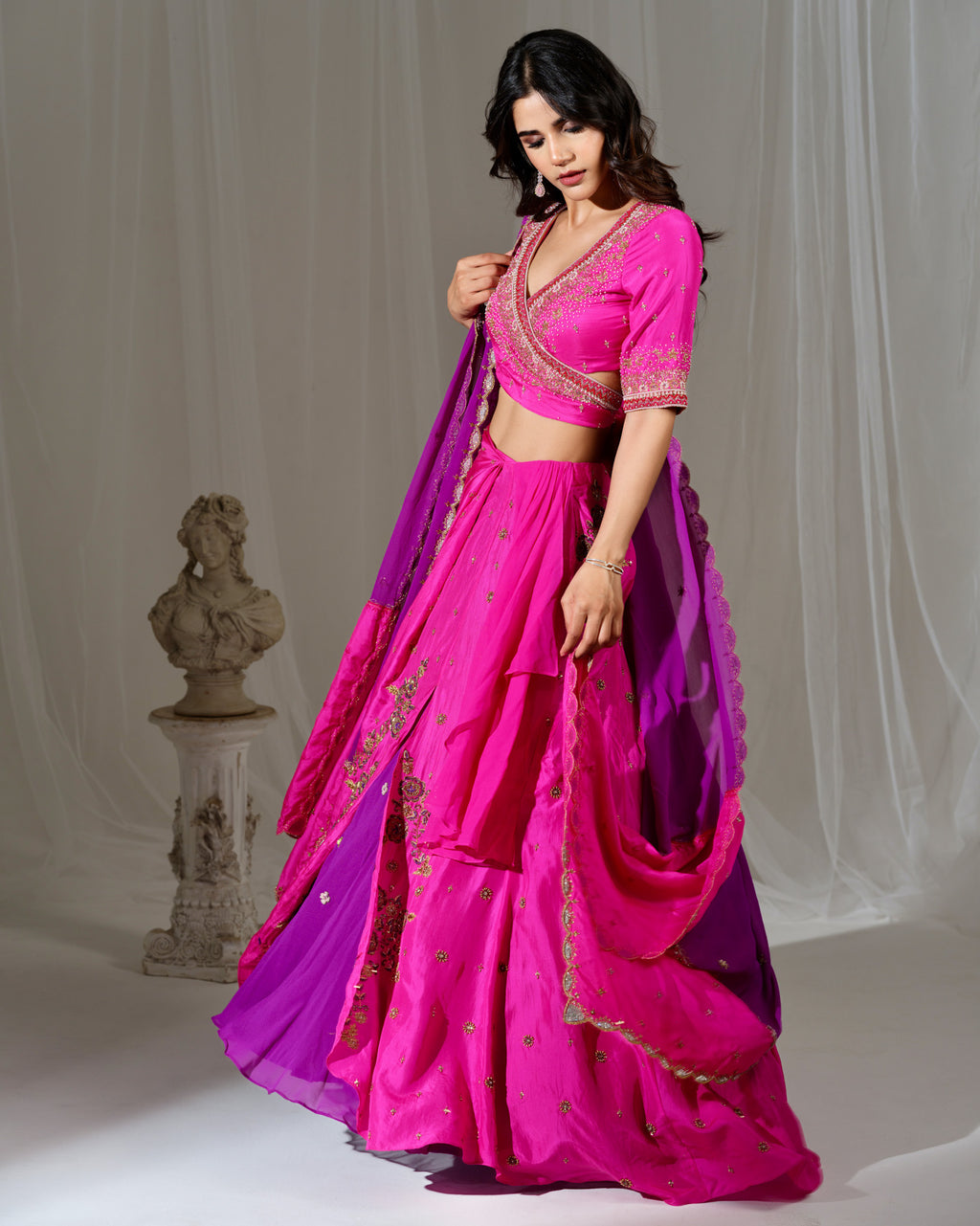 Woman in a pink and purple traditional outfit with a white background