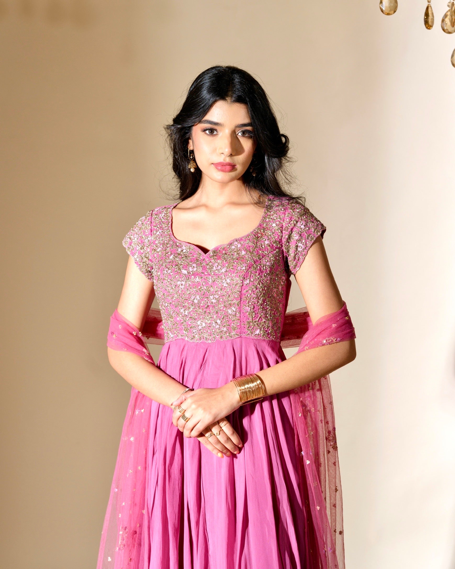 Woman wearing a pink traditional outfit with a beige background