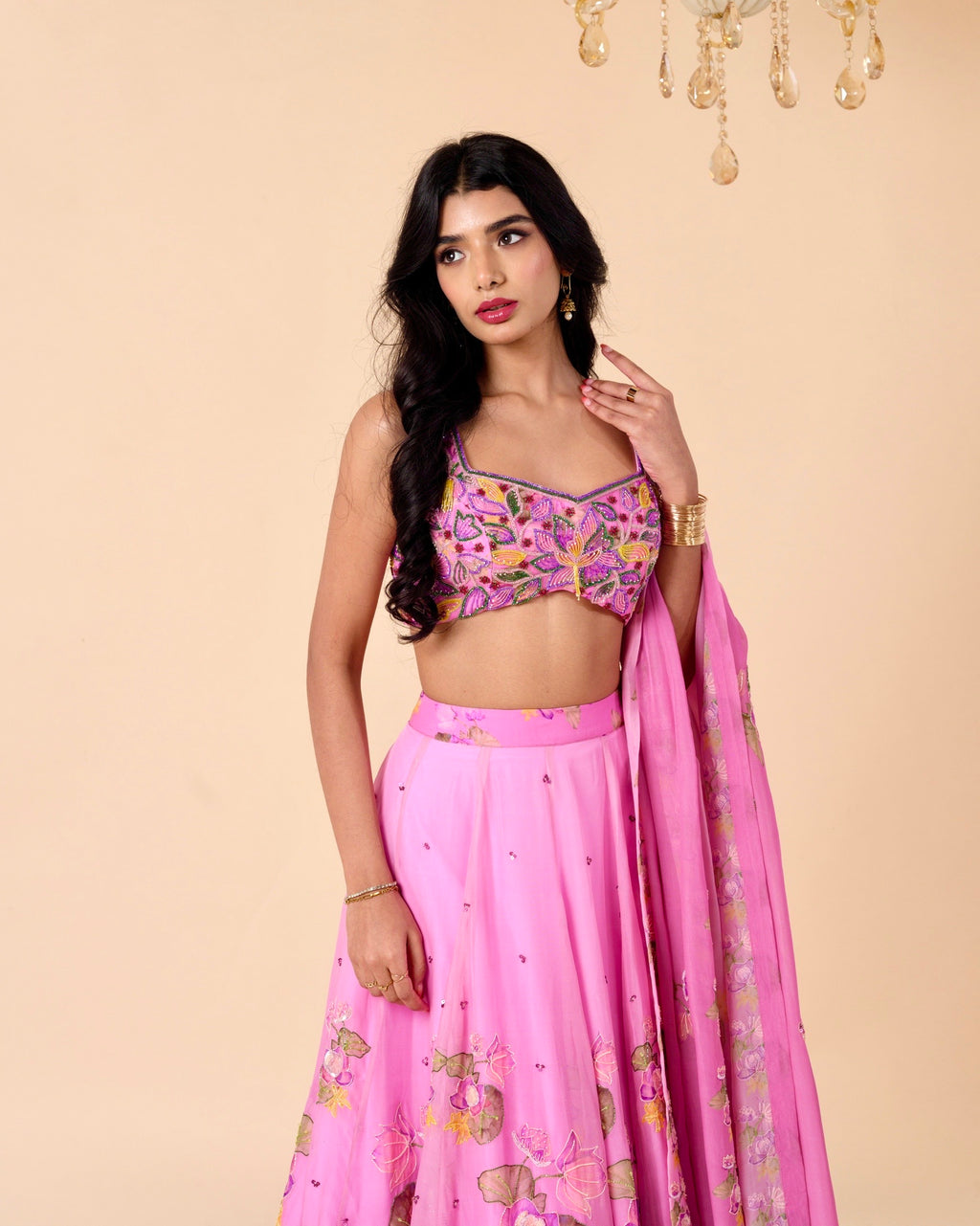 Woman wearing a pink traditional outfit with floral patterns on a beige background