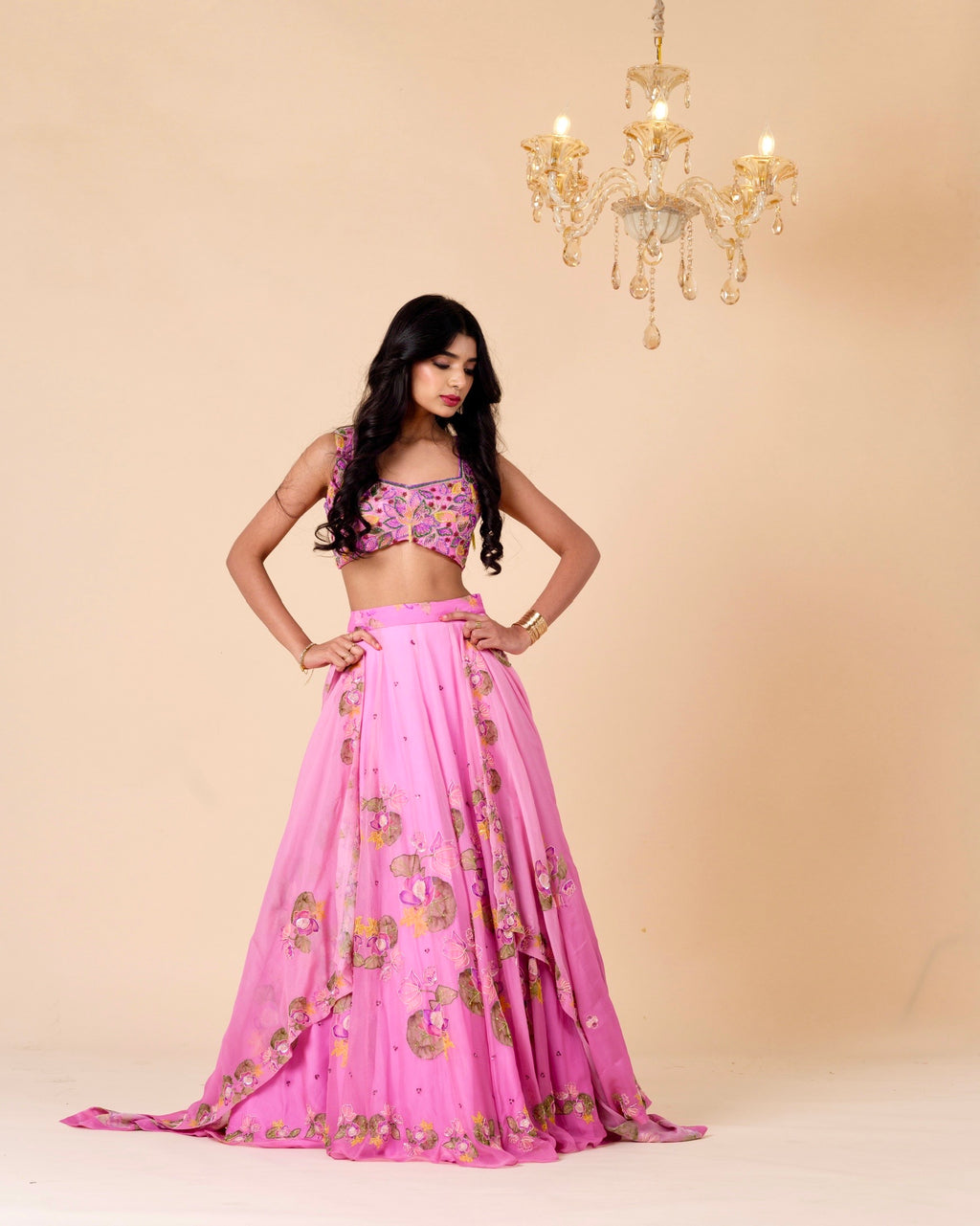 Woman wearing a pink traditional outfit with floral patterns against a beige background