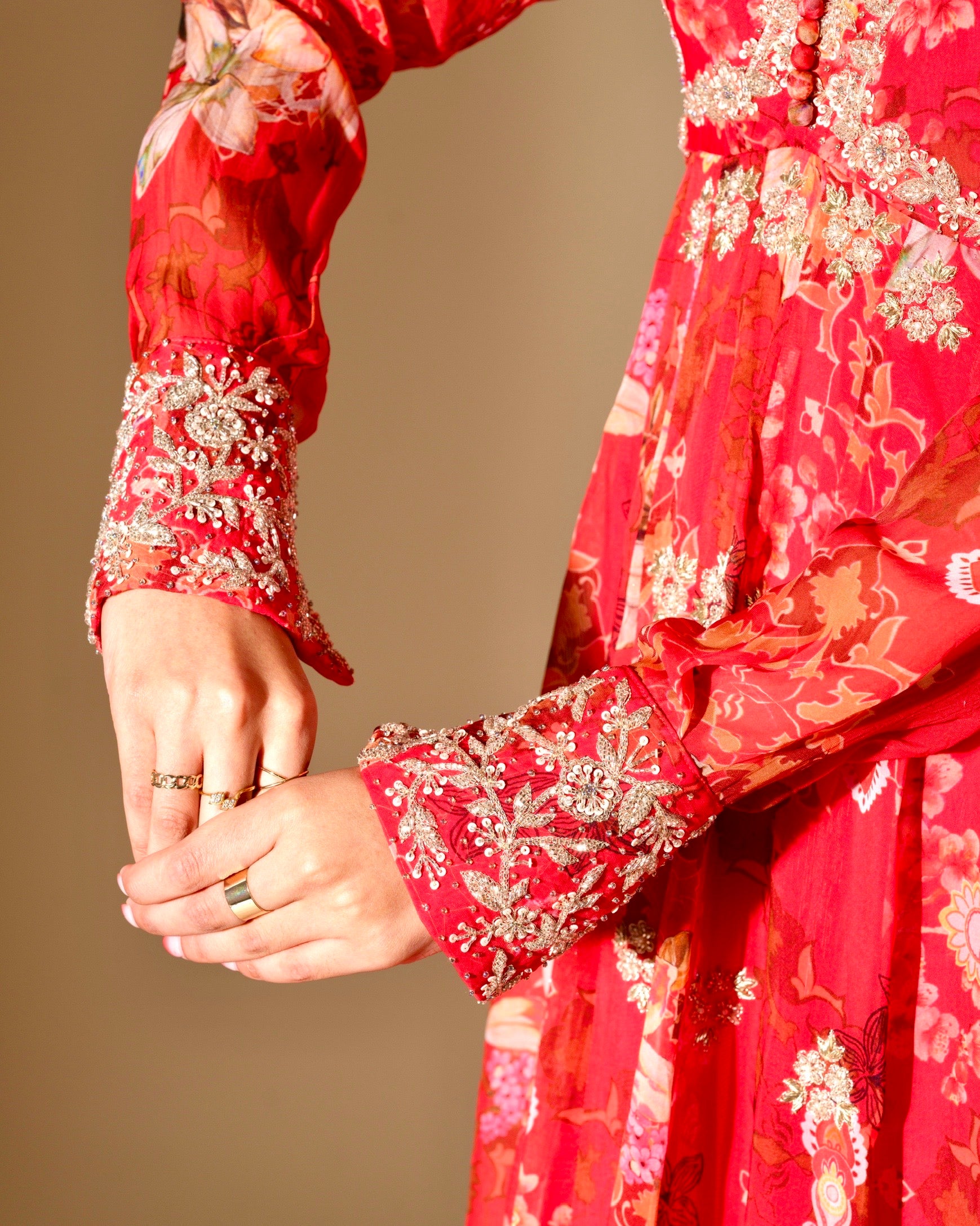 Red floral dress with intricate patterns on a beige background