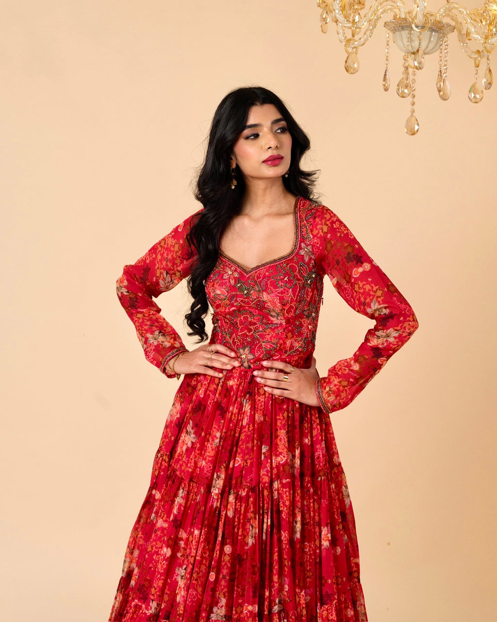 Woman wearing a red floral dress against a beige background