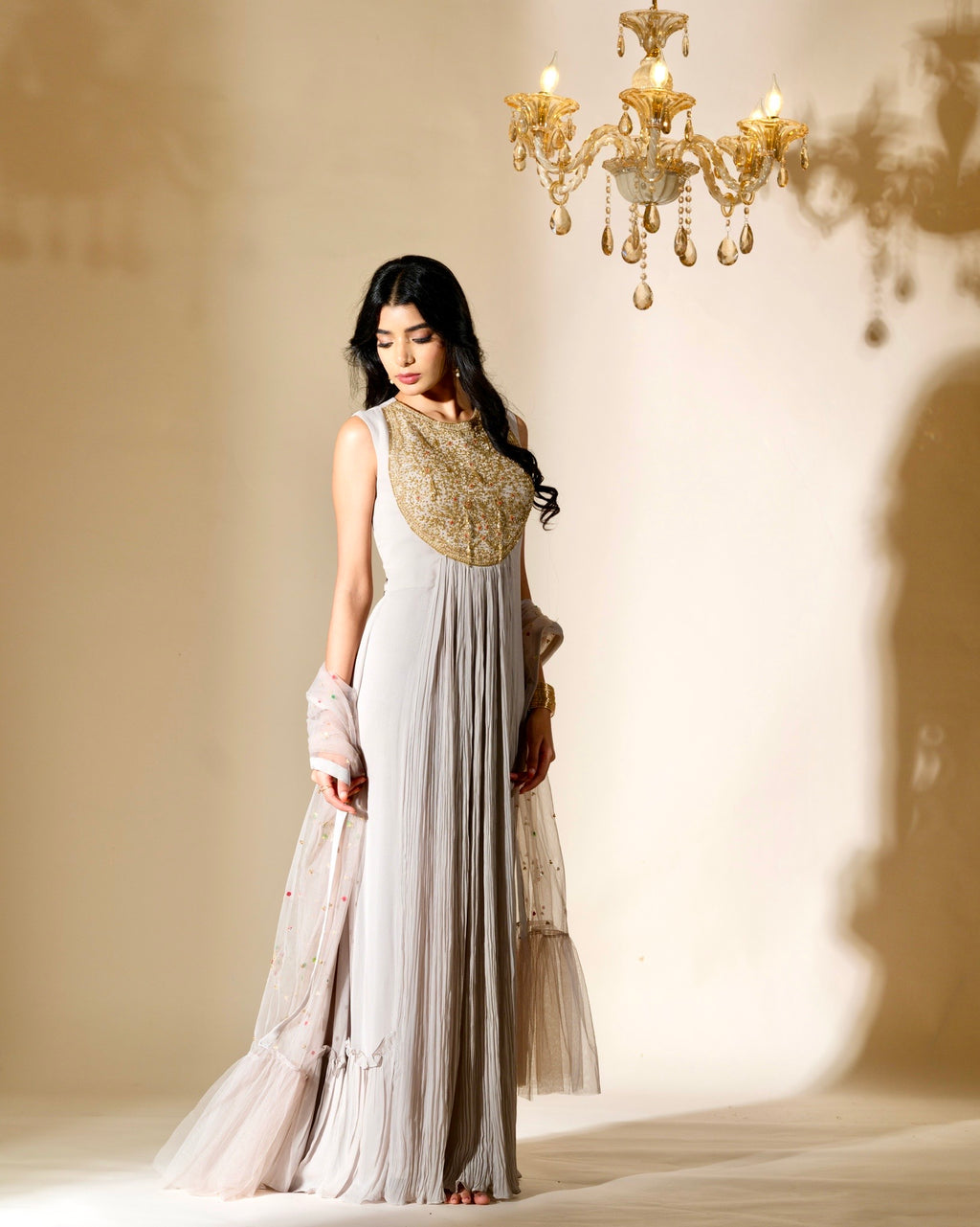 Woman in a traditional outfit with a chandelier in the background