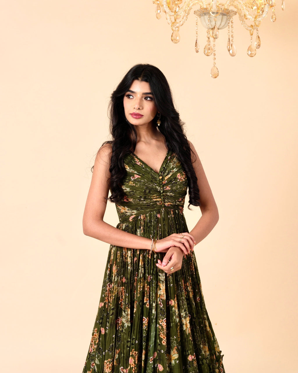 Woman wearing a green floral dress against a beige background