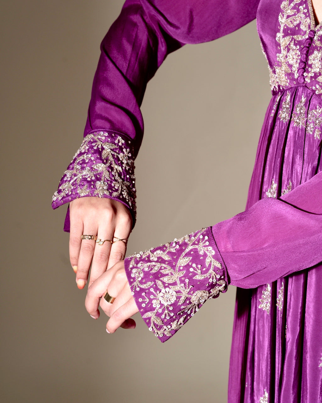 Purple dress with floral embroidery on cuffs against a neutral background