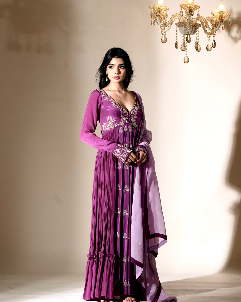 Woman wearing a purple dress with floral patterns in an elegant indoor setting.