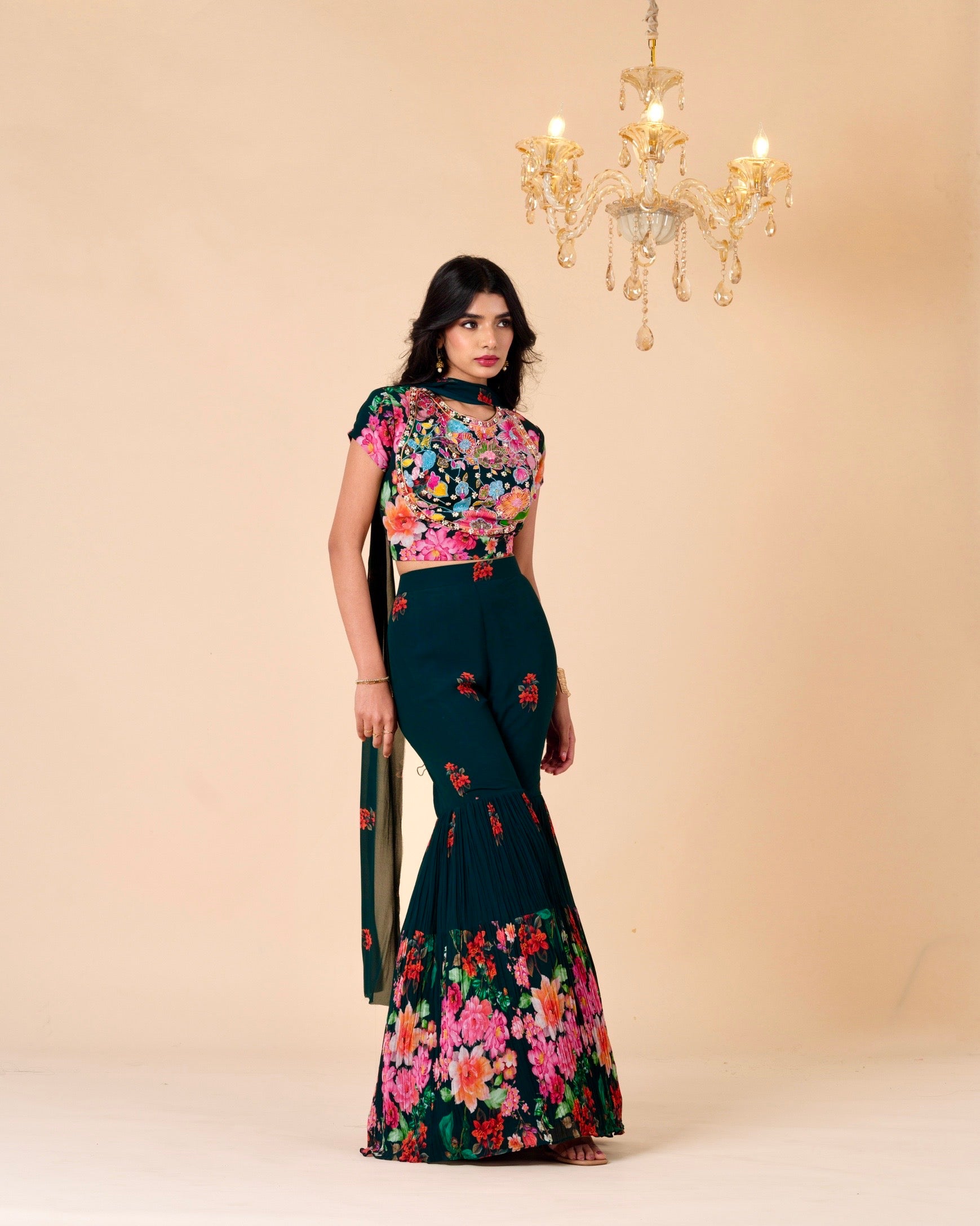 Woman wearing a floral outfit with a chandelier in the background